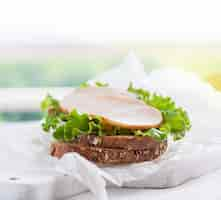 Free photo circular meat piece on top of lettuce and bread