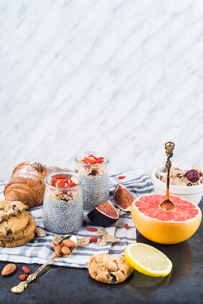 Free Photo citrus fruit slices; healthy smoothie with backed cookies and croissant on napkin