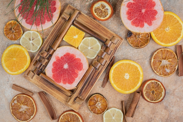 Citrus fruit slices in picture frame with bunch of fruits. High quality photo