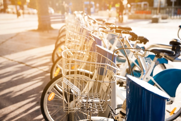 City bicycles with metal basket for rent stand in a row on a cobbled street