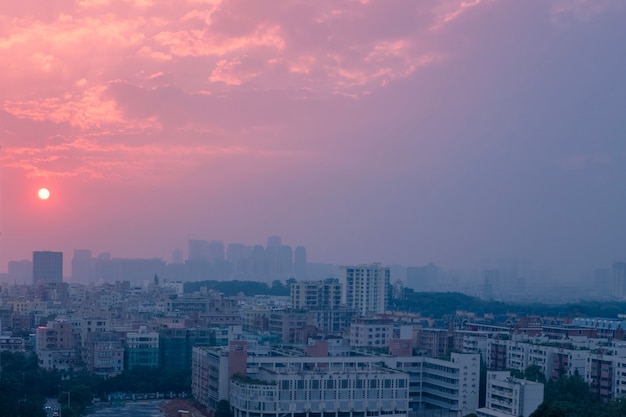 Free photo city under a cloudy sky during the pink sunset in the evening