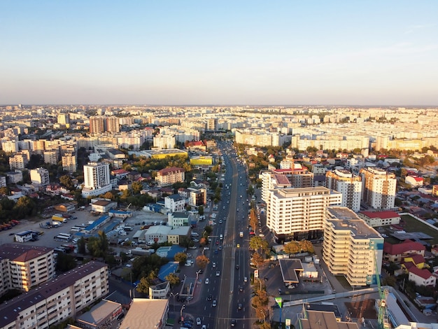 Cityscape of Bucharest, road with moving cars, multiple residential buildings, clear sky, view from the drone, Romania