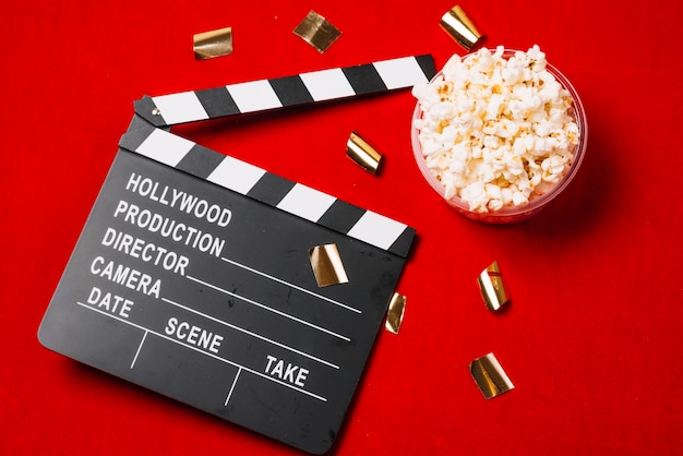 Free photo clapperboard near small bowl of popcorn