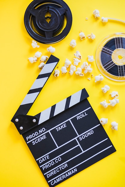 Free photo clapperboard with popcorn and reels