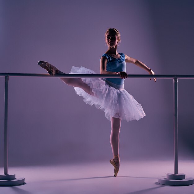 Classic ballerina posing at ballet barre