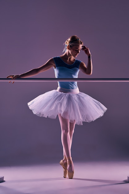 Classic ballerina posing at ballet barre