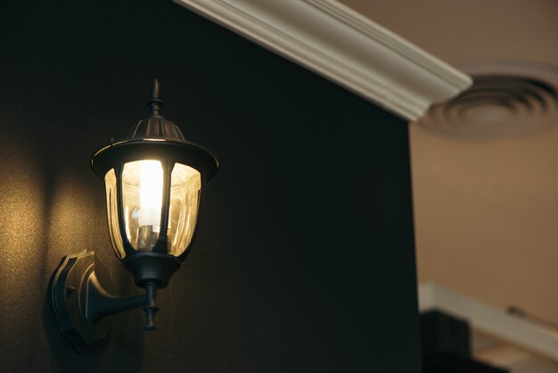 Classic lamp on black wall.