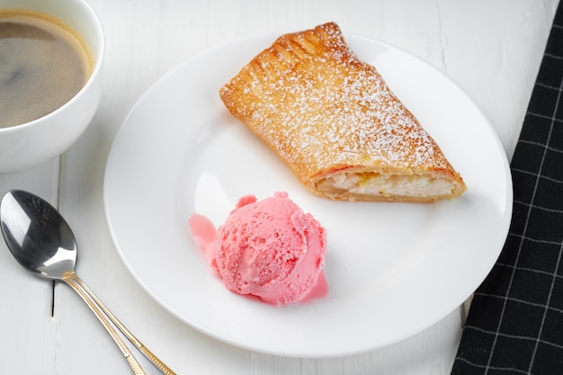 Classic shtrudel dessert with ice cream on white plate