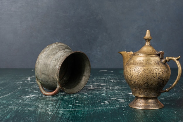 Free Photo classic teapot and vase on marble table.