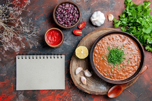 Classic tomato soap beans garlic spoon oil bottle lemon ketchup and notebook on mixed color table