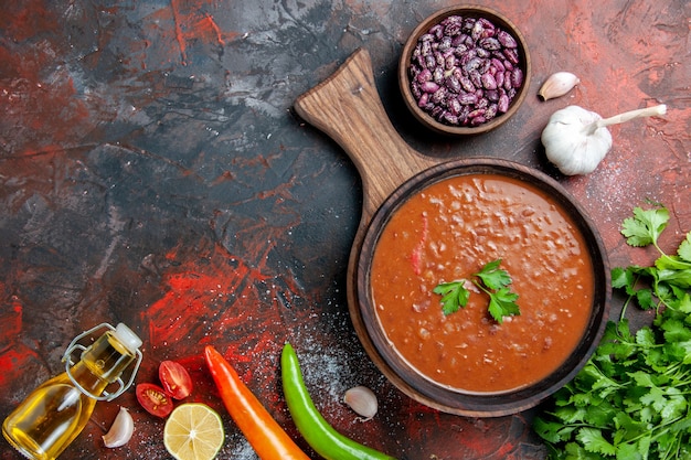 Classic tomato soup fallen oil bottle beans on cutting board on a mixed color table