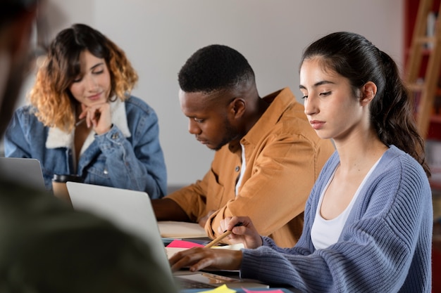 Classmates learning together from laptop and notes