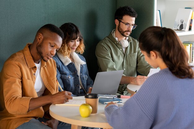 Classmates learning together from notes and laptop