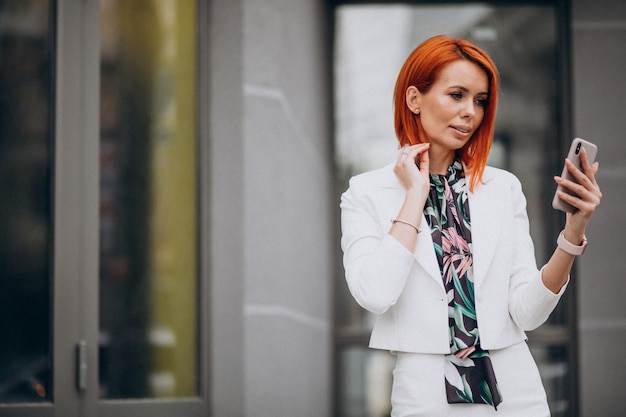 Free photo classy business woman in white suit talking on the phone