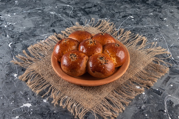 Free Photo clay plate of fresh pastry with sesame seeds on marble table.