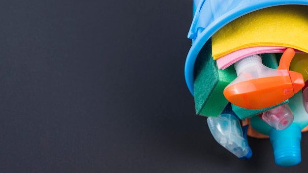 Cleaning products in basket over black background