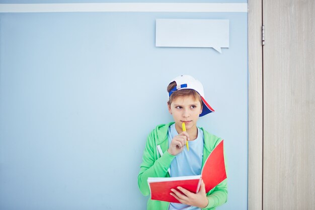 Clever kid thinking with a notebook