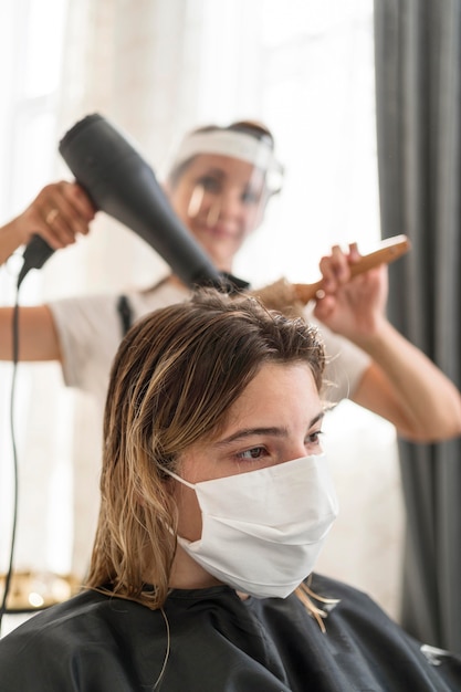 Client at hair salon wearing medical mask