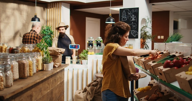 Free photo client placing vegetables in paper bag