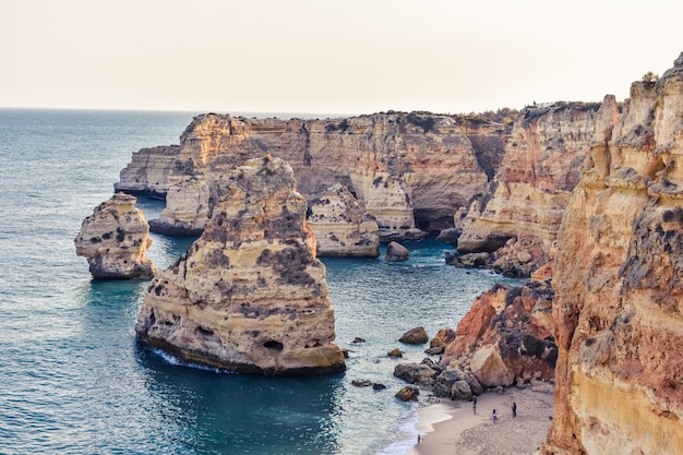 Cliffs sticking out of the water during daytime