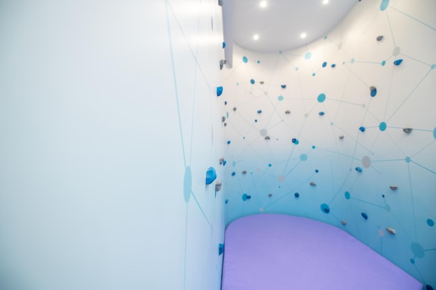 Climbing wall in lighted room with soft floor