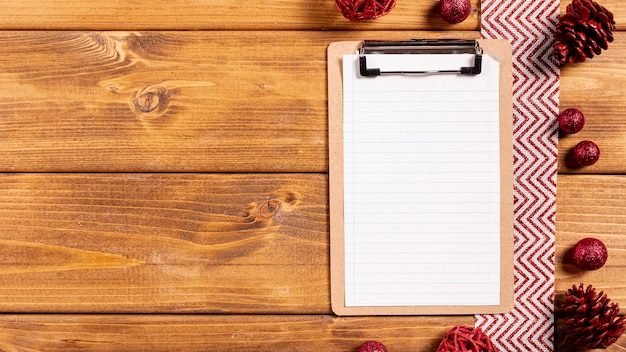 Clipboard and christmas decorations on wooden table