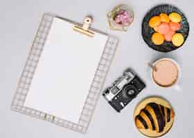 Free photo clipboard with camera, cookies and croissant