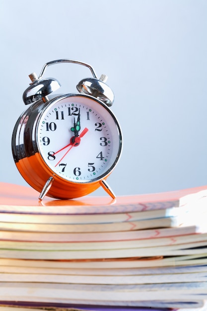 Free photo clock on a stack of notebooks