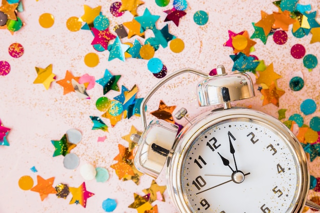 Free photo clock with bright spangles on table