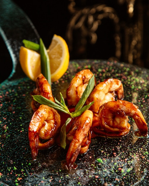 Clode up view of fried shrimps with lemon on the table