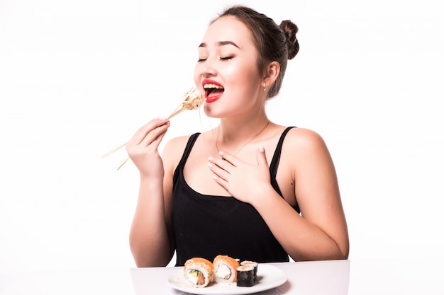 Free Photo close portrait of a beautiful woman eating sushi rolls