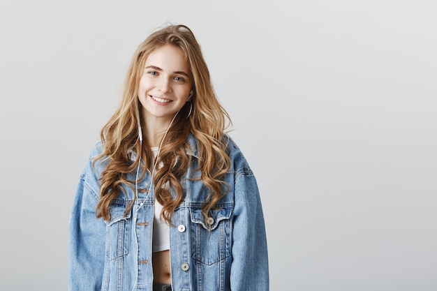 Free photo close-up of adorable blond girl smiling as listening music in headphones