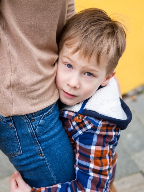 Close-up adorable young boy holding his mother