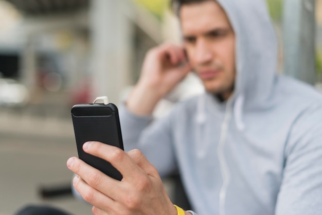 Close-up adult man browsing his mobile phone