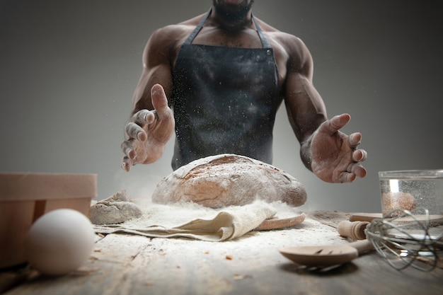 Close up of african-american man cooks fresh cereal, bread, bran on wooden table. Tasty eating, nutrition, craft product