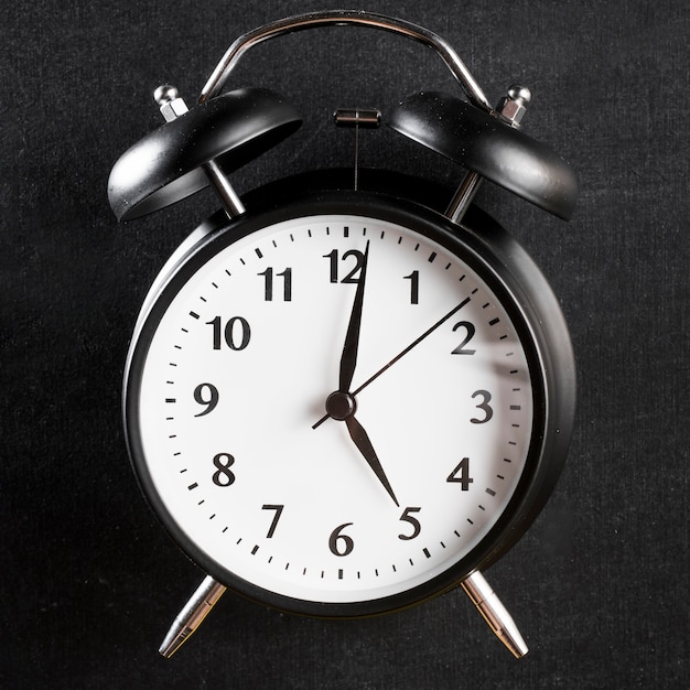 Free Photo close-up of an alarm clock on black background