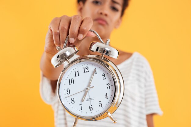 Close up of alarm clock in woman's hand isolated