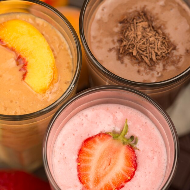 Close-up of assortment of milkshakes with chocolate and fruits