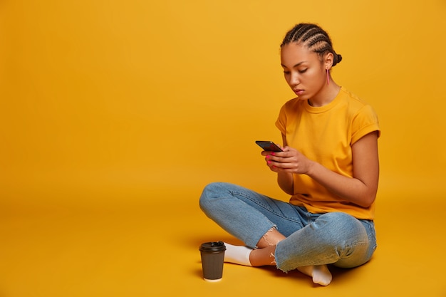 Close up on attractive carefree young woman sitting on the floor