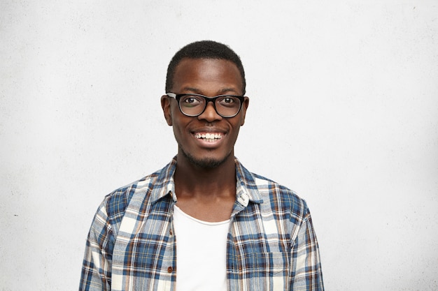 Close up of attractive smart-looking smiling dark-skinned male model posing