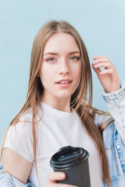 Close-up of attractive young female holding coffee cup