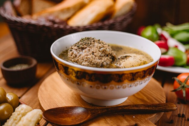 Close up of azerbaijani kofta meatball soup garnished with dried mint leaves