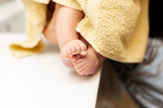 Free photo close-up baby legs with yellow towel