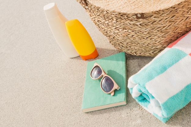 Close-up of bag and beach accessories on sand