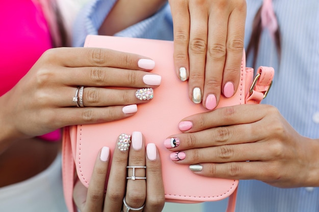 Free photo close up of bag with girls hands with manicure over it.