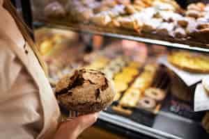 Free photo close up baker holding bread