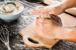 Free photo close-up of baker's hand kneading bread dough