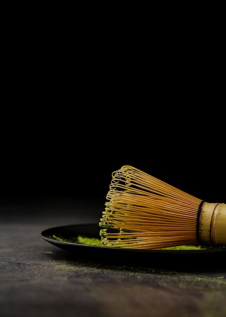 Free photo close-up of bamboo whisk on plate with match tea powder