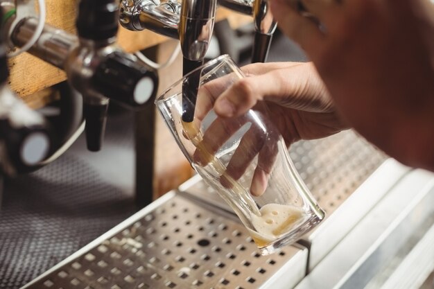 Close-up of bar tender filling beer from bar pump