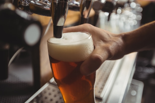 Close-up of bar tender filling beer from bar pump